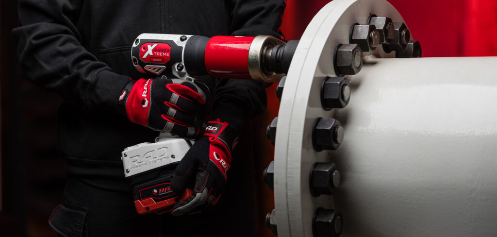A man holding the B-RAD X 3000 up to a bolt while wearing a black hoodie and RAD gloves